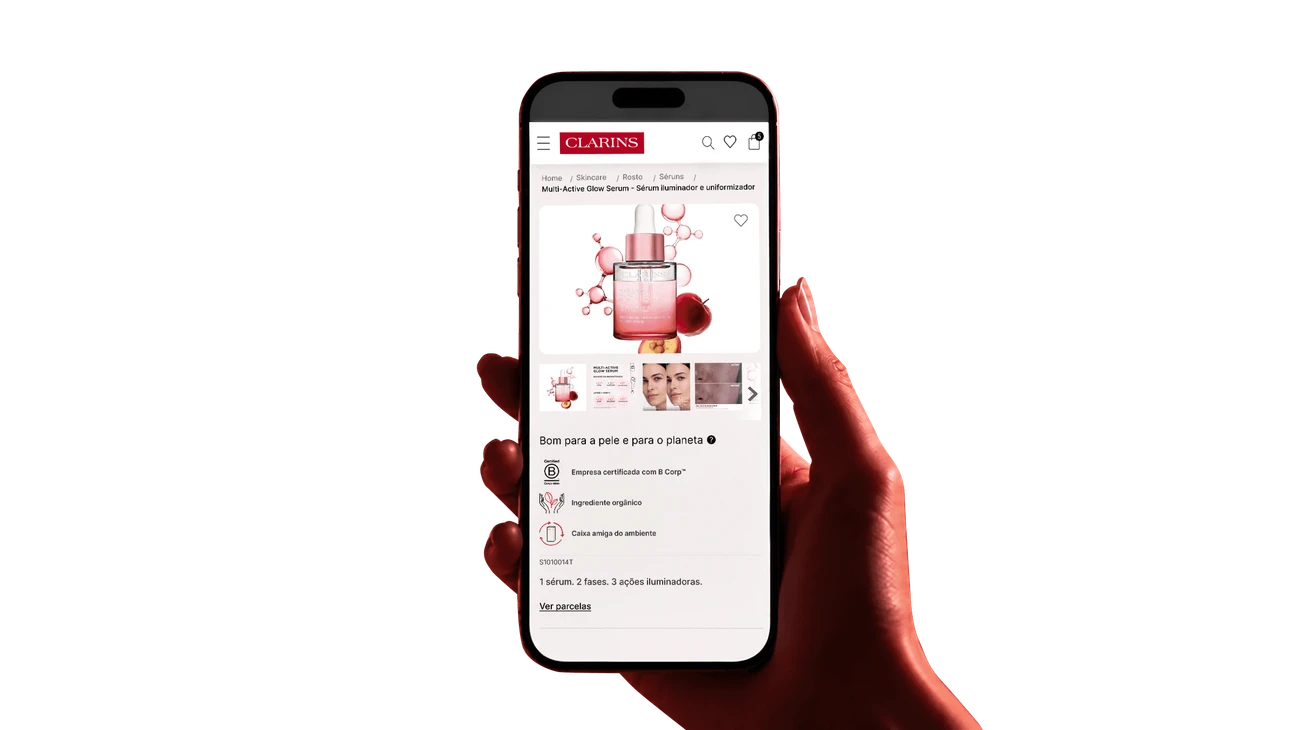 Mão segurando um celular com a página de produto da Clarins